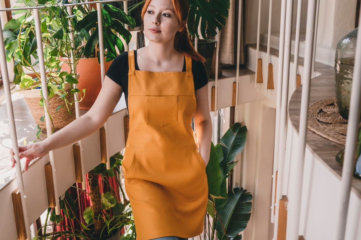 A woman in an orange apron standing on a balcony
